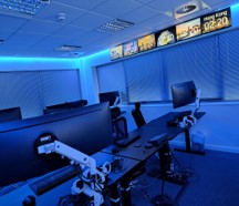 A NOC with desk and chairs and screens in future looking room- Maximizing Network Reliability