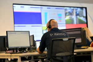 Indigo employee at a support desk surrounded by screens